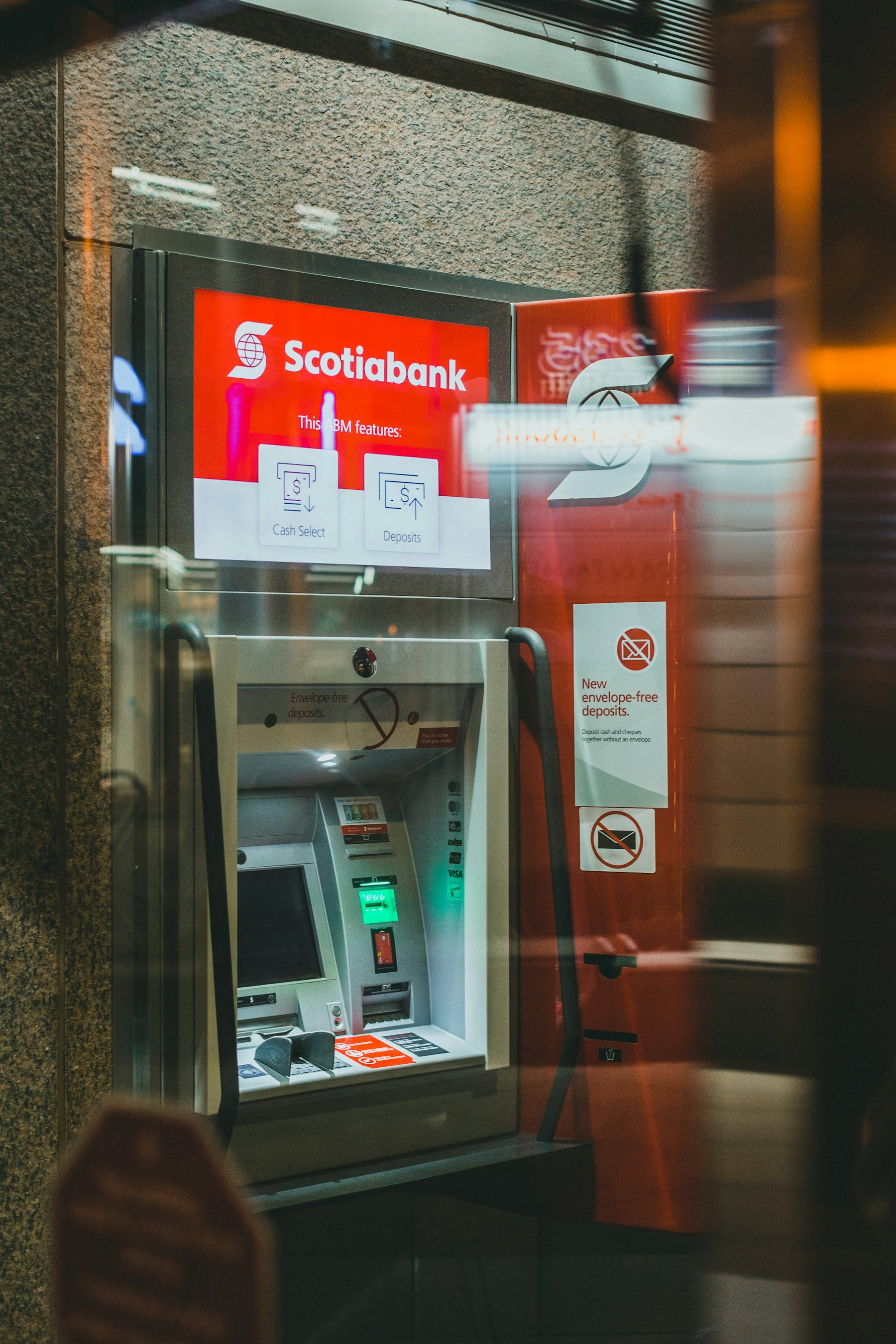 A red and white ATM machine photographed on location